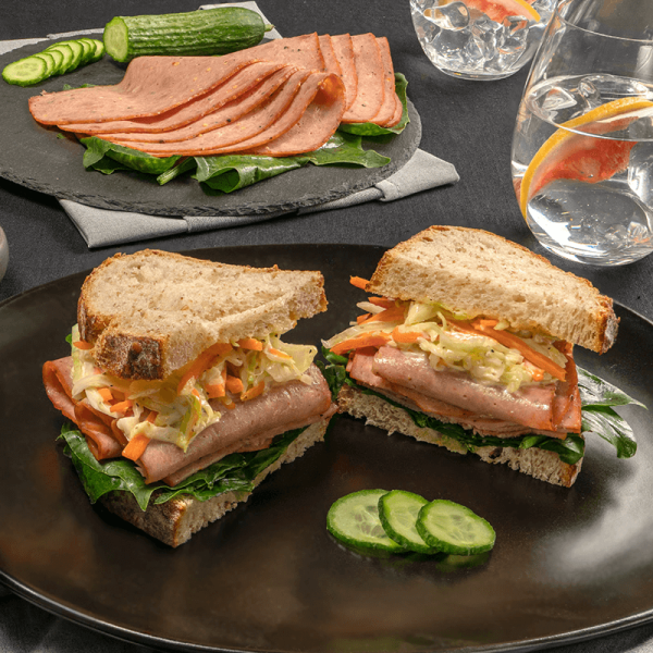 Sandwich de Pastrami Tangamanga con pan artesanal, ensalada de col y zanahorias.